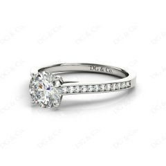 Round Cut Four Claw Set Diamond Ring with Round Cut Channel Diamonds Down the Shoulders and on the Setting in 18K White